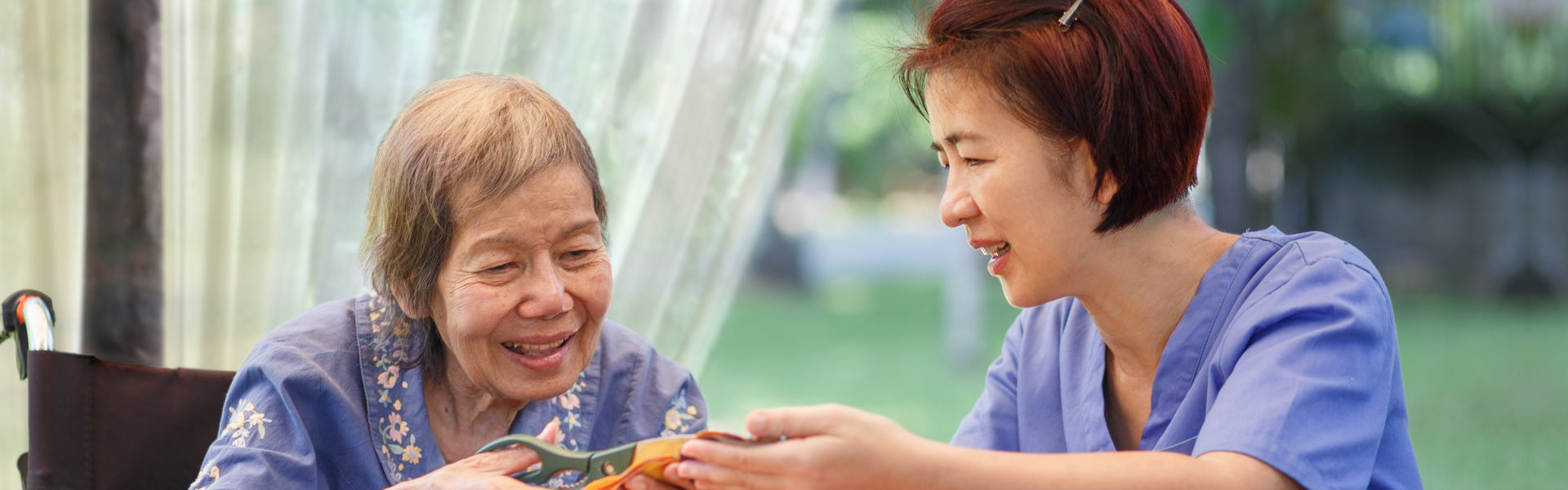 A health professional woman assist a senior woman on art activity